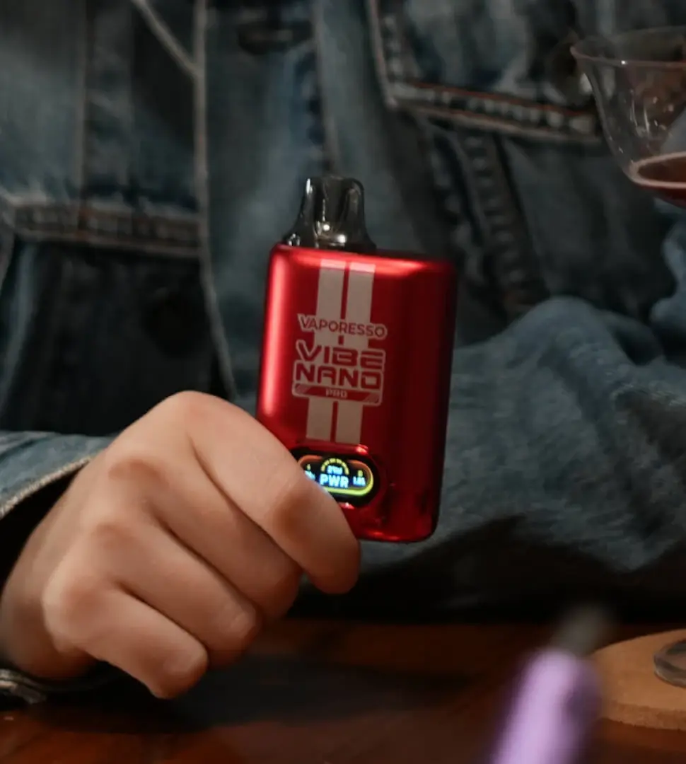 The VAPORESSO VIBE NANO PRO vape pod starter kit held in hand, showcasing its bright screen. A perfect flavor vape for relaxing moments.